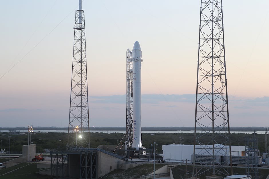 Space rocket installed on metal construction in spaceport and ready for launching against cloudless sky