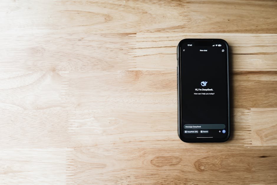 A smartphone featuring an AI assistant app, placed on a light wooden table, showing tech and communication.