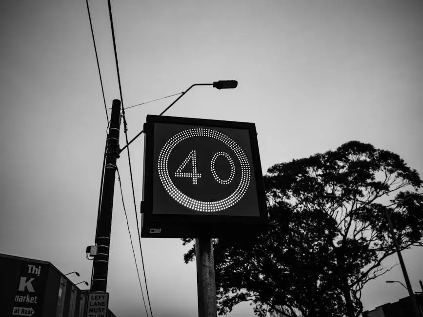 Black and white image of a 40 speed limit sign with urban backdrop.