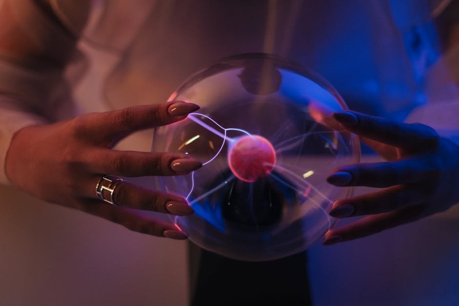A woman elegantly holds a glowing plasma globe, creating stunning visual effects.