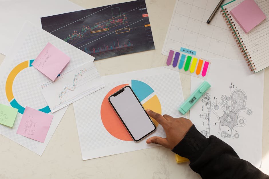 Creative workspace with charts, phone, and stationery, ideal for business planning.