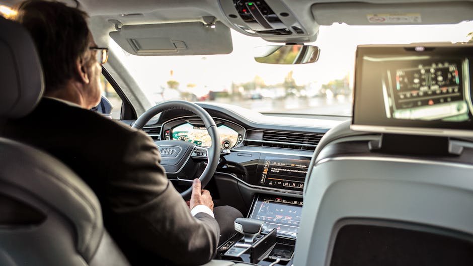 Businessman driving a modern luxury car, showcasing advanced dashboard and navigation systems for comfort and control.