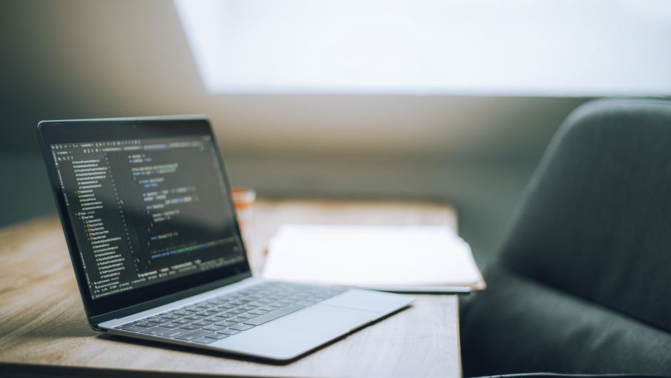 A junior programmer at a desk surrounded by AI tools and job market data showing rising automation and skill demands