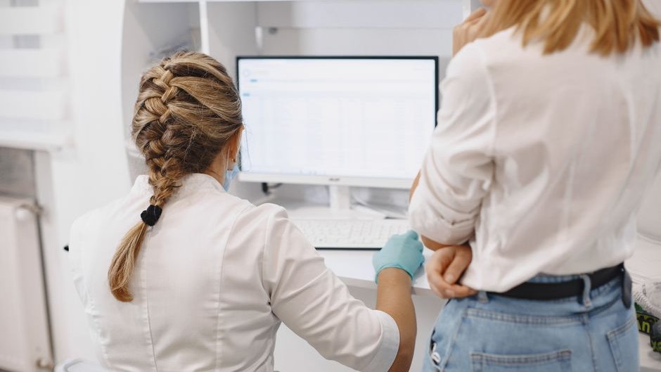 Nurses review AI-generated patient care metrics on a screen, prioritizing speed over thoroughness in treatment decisions