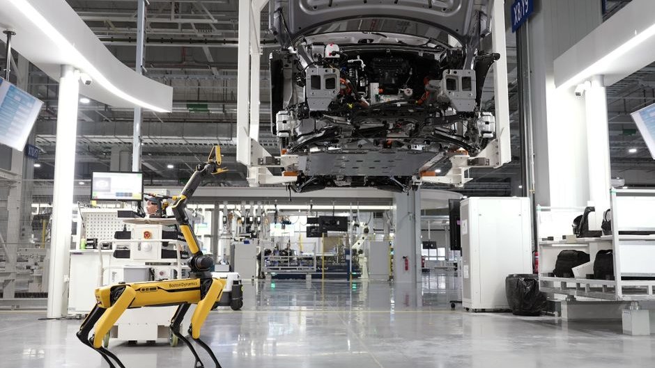A technician uses AI-powered vision systems to inspect product quality on a factory assembly line