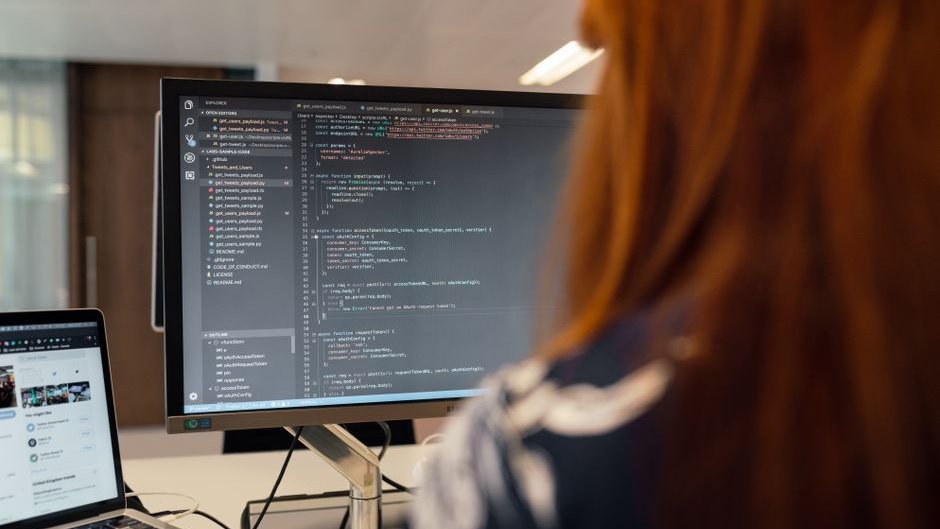 A developer reviews code with AI-generated suggestions causing confusion and delays in a cluttered workspace highlighting the AI developer productivity gap