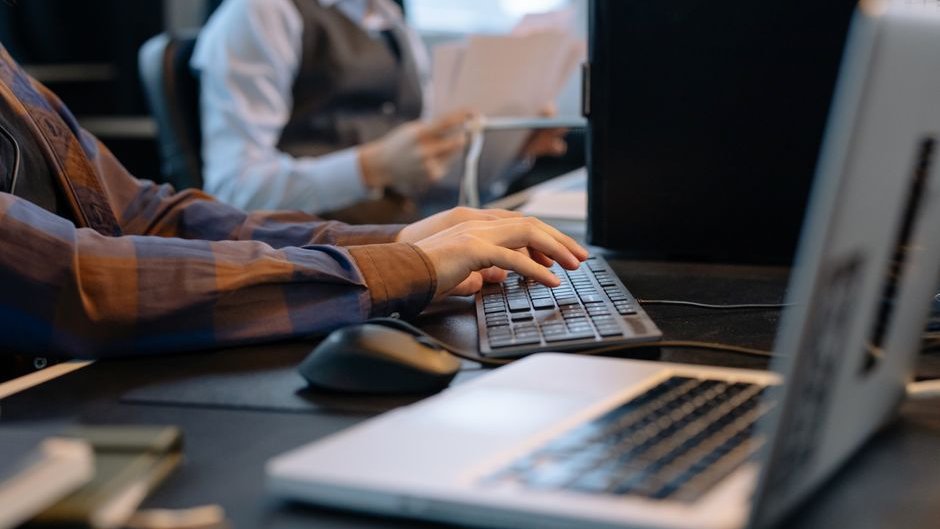 A professional consults an AI device, deferring complex decision-making as reliance on AI thinking offloading increases