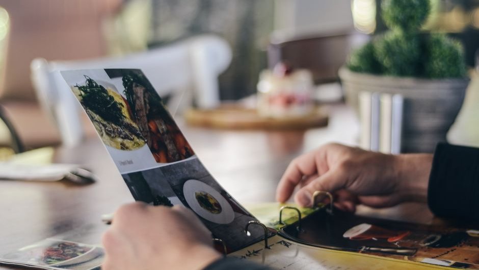 A chaotic AI-generated menu redesign with clashing colors and generic icons fails to reflect the brand's identity