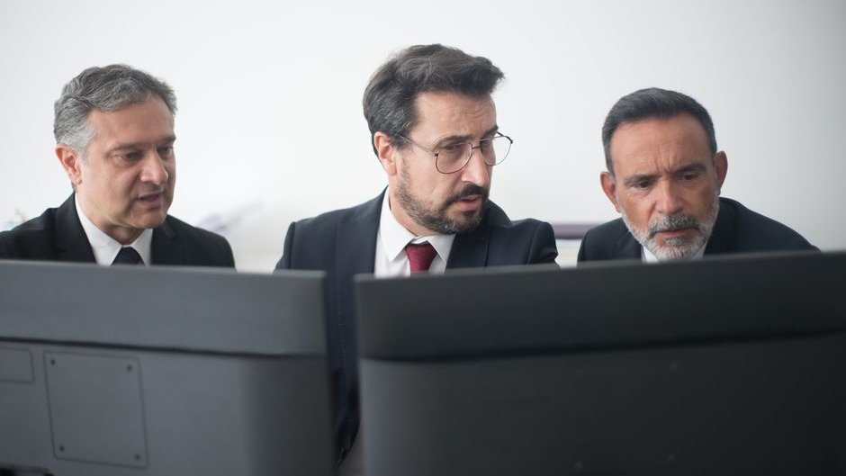 An executive reads glowing chatbot text on a laptop, exposing AI leadership blind spots