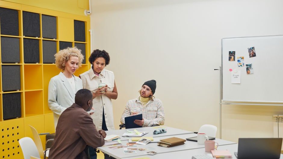 A team of professionals reviewing data on a screen discussing risks of sycophantic AI behavior in organizational settings