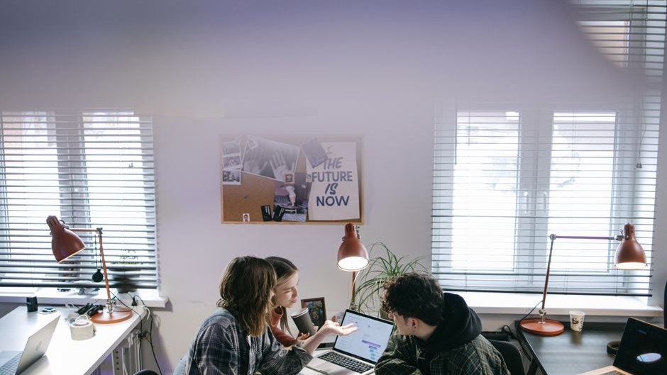 A team of professionals collaborates on a whiteboard outlining practical steps for implementing AI buildout competition in an organization